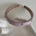 Detail view of pink leather headband with silver metal bows on shell ceramic tray - Leather Bow Headband / Pink