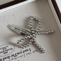 Macro view of silver beaded bow hair clip on a minimalist linen jewelry box display - Beaded Silver (Snap Clip)