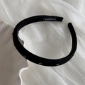 Dettaglio di cerchietto fatto a mano in raso nero con strass decorativi su sfondo bianco - Cerchietto con Strass / Nero
