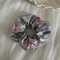 Detail of silver metallic scrunchie featuring decorative small pink string bows - Silver Scrunchie - Pink Bow