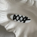 Detailed view of white acrylic hair clip with black ribbon bow and corset style lacing - Black Ribbon