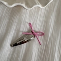 Detail of a pink string bow on a silver teardrop hair clip against a soft white fabric - Silver Clip - Pink Bow
