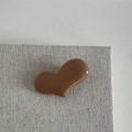 Dettaglio di un fermaglio per capelli a forma di cuore marrone lucido su tessuto - Fermaglio Cuore Marrone Chiaro
