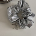 Vue détaillée du pendentif nœud argenté sur un bandeau plissé en similicuir - Chouchou / Argent