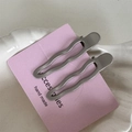 Gros plan de deux barrettes à cheveux ondulées argent mat sur carte rose - Vague Creuse / Paire de Perles Gris Argent