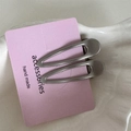 Gros plan de barrettes minimalistes en métal argenté sur carte rose avec texte fait main - Goutte d'eau / Paire de Perles Gris Argent