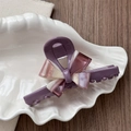 Detailed view of deep purple bow hair claw clip on white ceramic shell tray - Dust Rose
