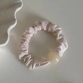 Dettaglio di elastico per capelli crema con perla traslucida e tessuto morbido a pieghe - Bianco Sporco