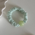 Dettaglio dell'elastico increspato verde menta con una decorazione a sfera gelatina - Verde Chiaro