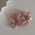 Detail of pink satin bow hair clip featuring heart-shaped pearls on a clean white surface - Girl Pink Heart