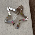 Détail de la pince à cheveux en forme d'étoile avec pois colorés sur une surface en toile - Argent avec pois colorés Pince étoile