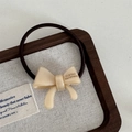 Makroaufnahme von cremefarbenem Acetat-Haargummi mit handgefertigtem Goldlogo-Detail - Schleifen Haarband-Reisweiß