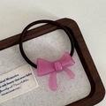 Rosa Acetat-Schleifen-Haargummi mit Perlenstruktur auf einem Schmucktablett aus Holz - Schleifen Haarband-Rosarot