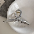 Macro shot of ink marble claw clip with gold spring in a minimalist ceramic dish setting - Extra Large Crisscross Claw Style (FJ892143)