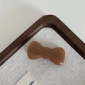 Detailed macro view of handmade acetate bow hair clip with gold France branding text - Light Coffee