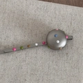 Detail of a silver metal hair clip with colorful polka dots on a round decorative disc - Round Matte Silver Bobby Pin