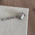 Detailed view of heart-shaped metal hair clip with colorful enamel polka dots on fabric - Heart Matte Silver Bobby Pin