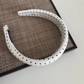 Dettaglio di un cerchietto imbottito con pois bianchi e neri su un supporto strutturato - Fascia Larga Pois - Bianco
