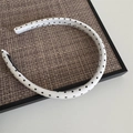 U-shaped white headband with black polka dots on a textured tray, minimalist hair accessory - Narrow Polka Dot Headband - White