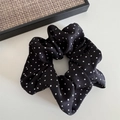 Dettaglio di un elastico per capelli nero a pois bianchi in tessuto satinato su fondo bianco - Elastico con Motivo a Pois - Nero