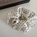 Dettaglio ravvicinato dell'elastico scrunchie a pois con texture plissettata e tessuto morbido - Elastico con Motivo a Pois - Bianco