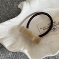 Detailed macro view of yellow resin hair tie charm with France handmade engraving - Apricot