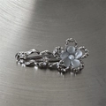 Detailed macro view of silver flower hair clip with rhinestones and opal-like resin beads - Flower