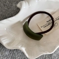 Detailed close-up of olive green resin hair tie buckle with France Handmade engraving - Green