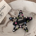 Detail of star-shaped black metal hair clip with colorful polka dots on a marble tray - Black Drip Oil - Hollow Star