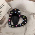 Close-up of heart-shaped black hair clip with colorful polka dots on marble tray - Black Drip Oil - Hollow Heart