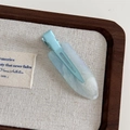Detail of light blue marbled hair clip with subtle glitter finish on a display tray - Mint Blue