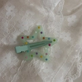 Close-up of star-shaped light green hair clip with colorful dots on lace background - Mint Green