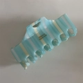 Détail macro d'une pince à cheveux en acétate rayé bleu avec logo doré fait main - Rayures Bleu Eau