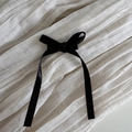 Vue détaillée du nœud en soie noire avec de longs rubans sur un tissu blanc - Noir