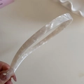 Close-up van een elegante crème acetaat hoofdband met marmeren textuur - Off-wit