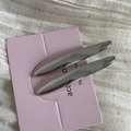 Gros plan de deux barrettes argentées brillantes en forme de fuseau sur carte rose - Argent Feuille de Saule