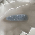 Detail of light blue quilted hair clip with white pearl beads on a ceramic tray - Blue