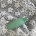 Gros plan d'une pince à cheveux mate vert menthe sur fond de dentelle blanche - Vert menthe