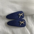 Detail of two navy denim fabric snap hair clips featuring golden braided bow accents - Dark Denim Metal Knot Teardrop