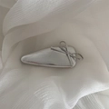 Detailansicht der silbernen Haarklammer mit Schleife auf elegantem weißem Chiffon-Stoff - Silberne Haarklammer - Silberne Schleife