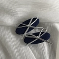 Close-up of denim fabric BB hair clips with silver bow detail on white fabric background - Dark Denim Leather Knot Oval