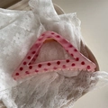 Detail einer rosa Haarklammer mit Punkten auf weißem Spitzenstoff Hintergrund - Erdbeerrosa Polka Dot - Großes Dreieck