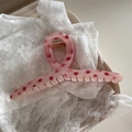 Detailed view of pink polka dot hair claw clip on white lace with high quality texture - Strawberry Pink Polka Dot - Hanger Shape