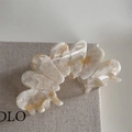 Detailed view of cream acetate hair claw clip with elegant marble texture and metal spring - Beige