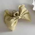 Detail of light yellow fabric bow hair claw clip showing textured material and metal spring - Bow Claw Clip / Yellow