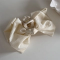 Detailed view of cream fabric bow claw clip with gold metal spring and 3D ribbon texture - Bow Claw Clip / Beige