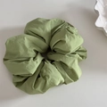 Detail of a large pleated sage green fabric scrunchie with soft textured layers - Scrunchie / Green