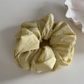Macro detail of a light yellow pleated fabric scrunchie on a minimalist white background - Scrunchie / Yellow