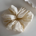 Detailed top view of a cream fabric scrunchie with soft pleated texture and floral shape - Scrunchie / Beige