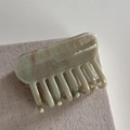 Close-up of sage green marble acetate hair claw with golden Barrette la France text - Green Marble